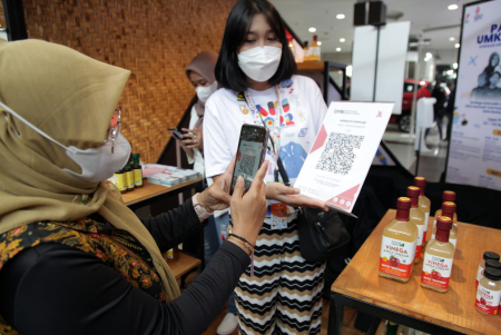 Penjual melayani pembeli melakukan pembayaran digital via QRIS saat pembelian produk UMKM pada pameran Apresiasi Kreasi Indonesia 2022 di Mall Lippo Plaza Sidoarjo, Jawa Timur, Jumat (2/9/2022). ANTARA FOTO